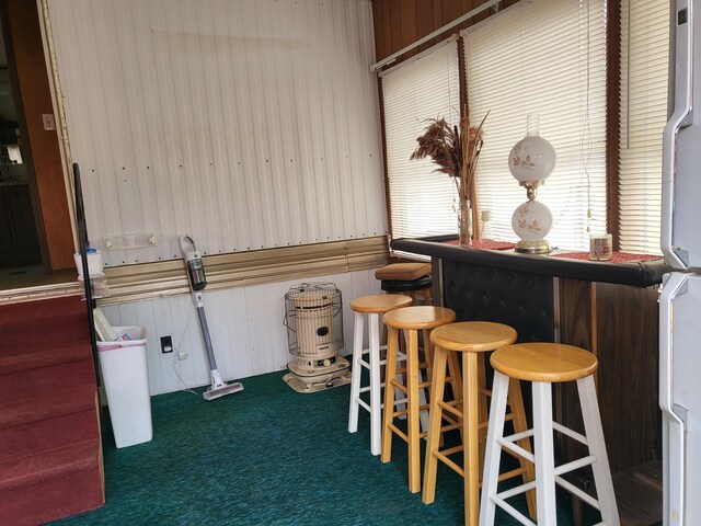 10675 N Shady Ln, Irons, MI 49644 - interior space featuring freestanding refrigerator, wooden walls, carpet floors, and a dry bar