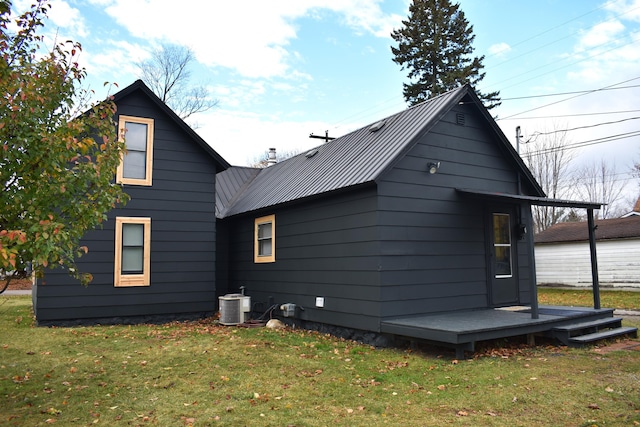 3785 S 2nd St, Onaway, MI 49765 - back of house with cooling unit, a yard, and metal roof
