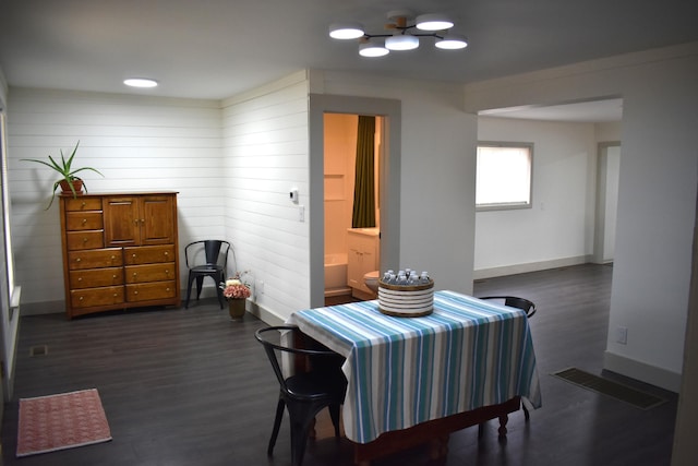 3785 S 2nd St, Onaway, MI 49765 - dining room with baseboards, wood walls, visible vents, and dark wood-type flooring