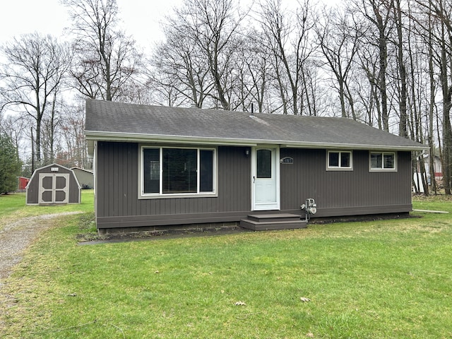 ranch-style house with an outdoor structure, a front yard, and a storage unit