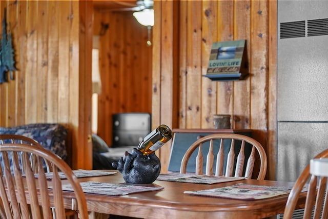135 Alpena Trl, Houghton Lake, MI 48629 - dining room featuring a heating unit, wooden walls, and ceiling fan