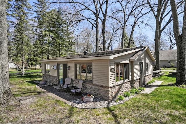 135 Alpena Trl, Houghton Lake, MI 48629 - view of property exterior with a lawn and stone siding