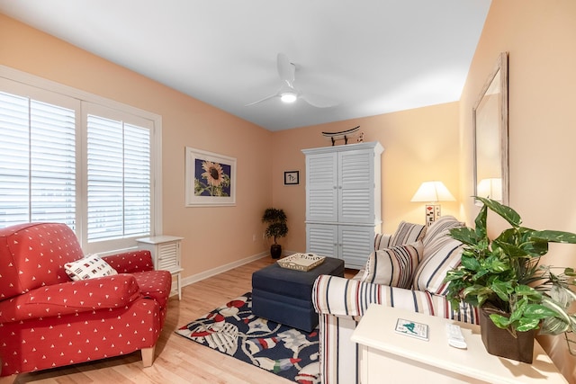 living area featuring a ceiling fan, wood finished floors, and baseboards