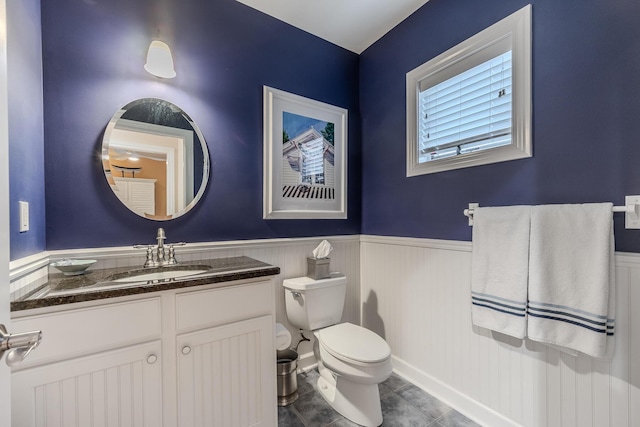 bathroom featuring wainscoting, toilet, vanity, and tile patterned floors