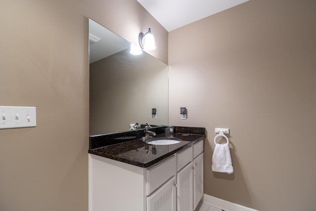 bathroom with vanity, baseboards, and tile patterned flooring