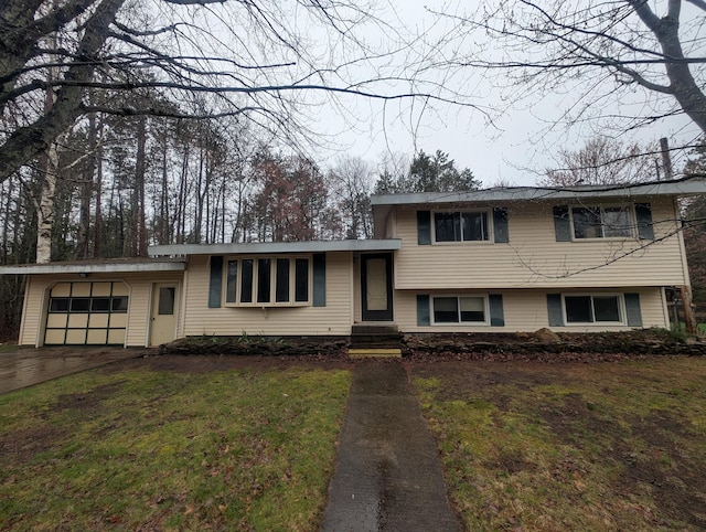 split level home with a garage, driveway, and a front yard