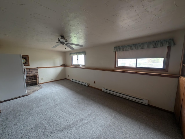 unfurnished living room with a baseboard heating unit, carpet flooring, ceiling fan, and baseboards