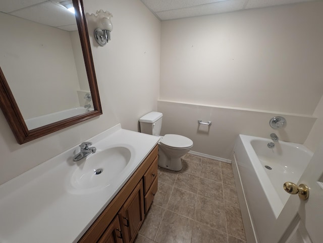bathroom featuring toilet, vanity, a bathtub, and baseboards