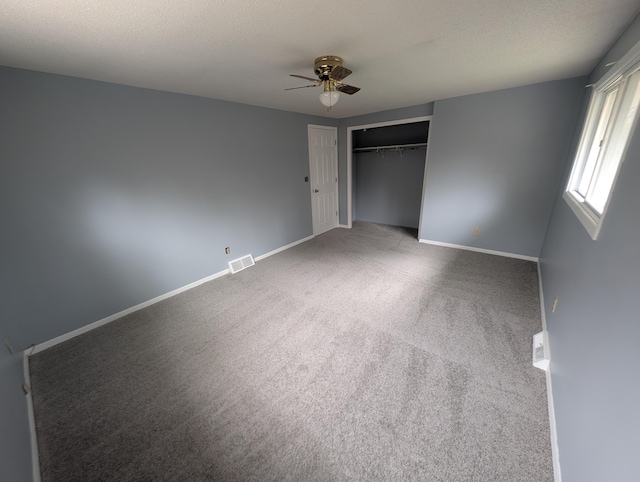 unfurnished bedroom featuring carpet, baseboards, a closet, and ceiling fan