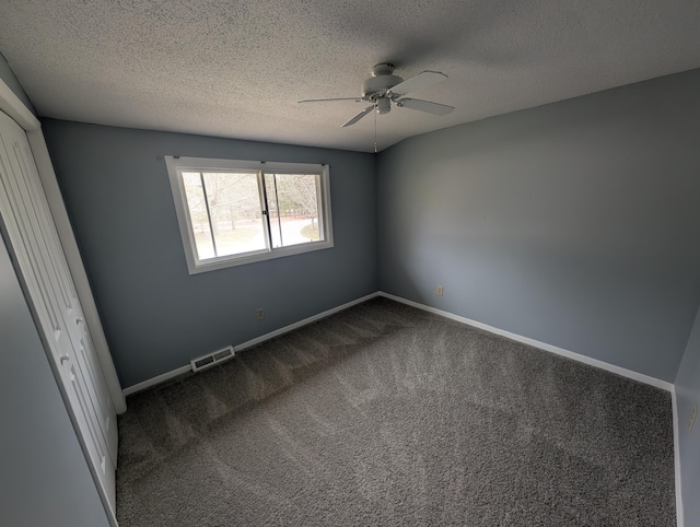 unfurnished bedroom with dark carpet, a textured ceiling, baseboards, ceiling fan, and a closet