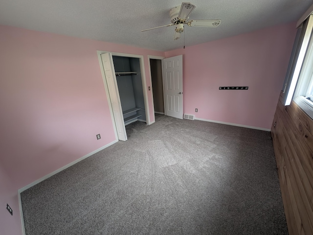 unfurnished bedroom with carpet floors, a textured ceiling, baseboards, a closet, and ceiling fan