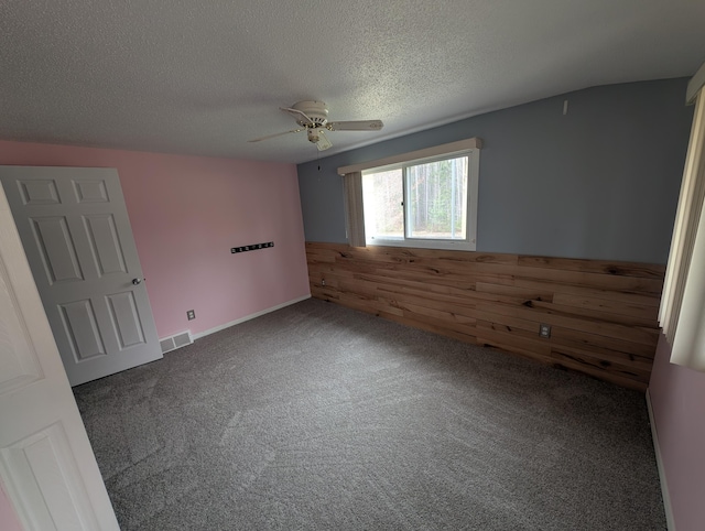 unfurnished room with ceiling fan, carpet floors, and a textured ceiling