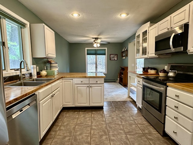 1243 Euclid Ave, Grayling, MI 49738 - kitchen featuring appliances with stainless steel finishes, wooden counters, a sink, a peninsula, and a ceiling fan