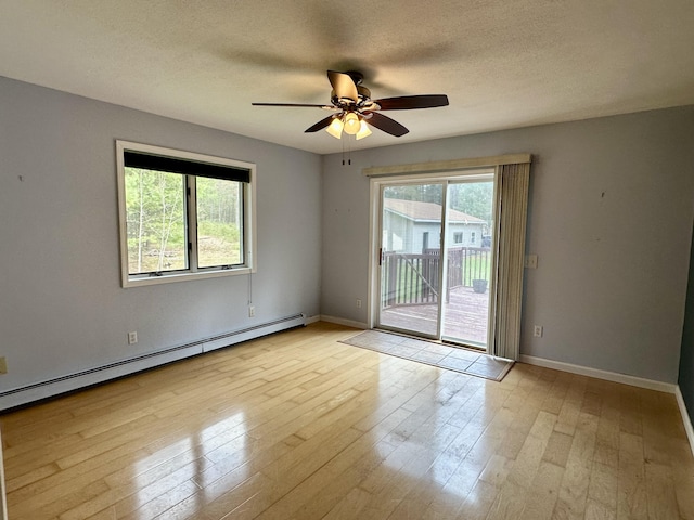 1243 Euclid Ave, Grayling, MI 49738 - empty room featuring a baseboard radiator, ceiling fan, light wood finished floors, baseboards, and a textured ceiling