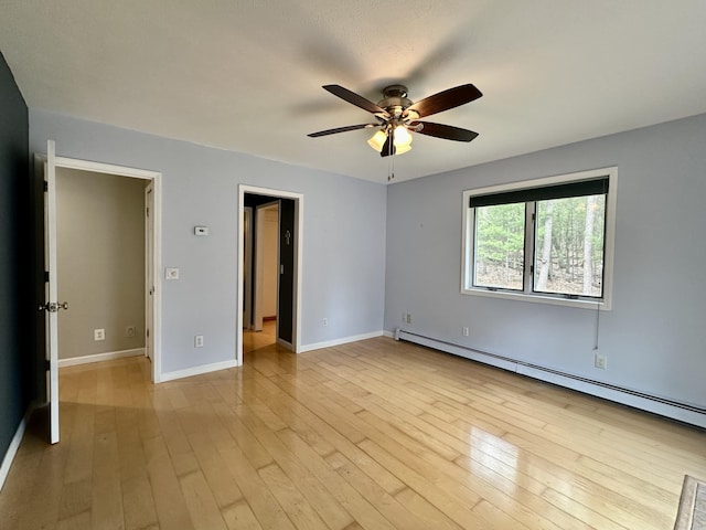 1243 Euclid Ave, Grayling, MI 49738 - spare room with a baseboard heating unit, ceiling fan, baseboards, and light wood-type flooring