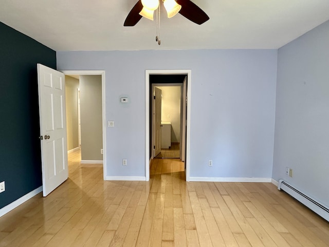 1243 Euclid Ave, Grayling, MI 49738 - unfurnished bedroom with baseboard heating, light wood finished floors, baseboards, and a ceiling fan