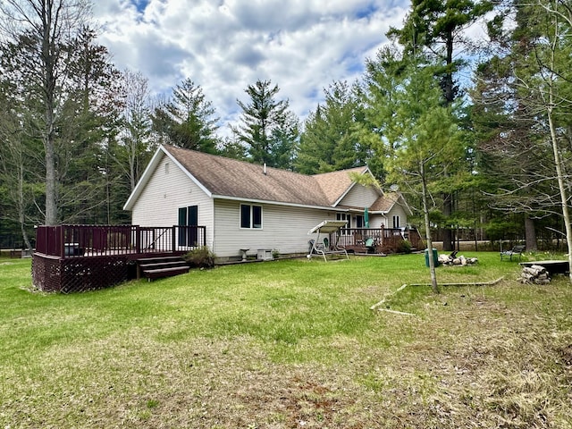 1243 Euclid Ave, Grayling, MI 49738 - rear view of house featuring a deck and a lawn