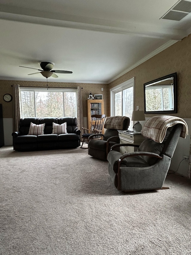 living area with carpet, ceiling fan, and beamed ceiling