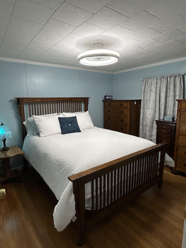 bedroom featuring wood finished floors and crown molding