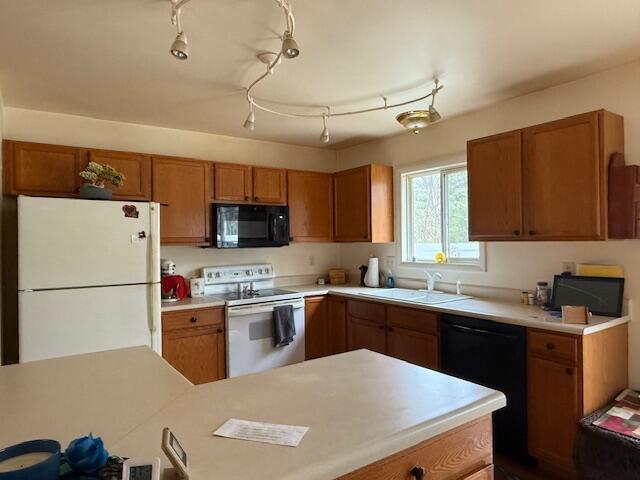 206 Great Oak Dr, Roscommon, MI 48653 - kitchen with black appliances, a sink, brown cabinetry, and light countertops