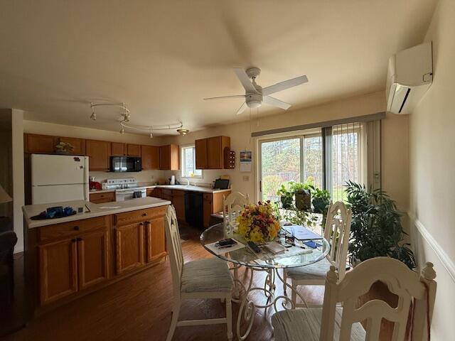 206 Great Oak Dr, Roscommon, MI 48653 - dining area with an AC wall unit, wood finished floors, and ceiling fan