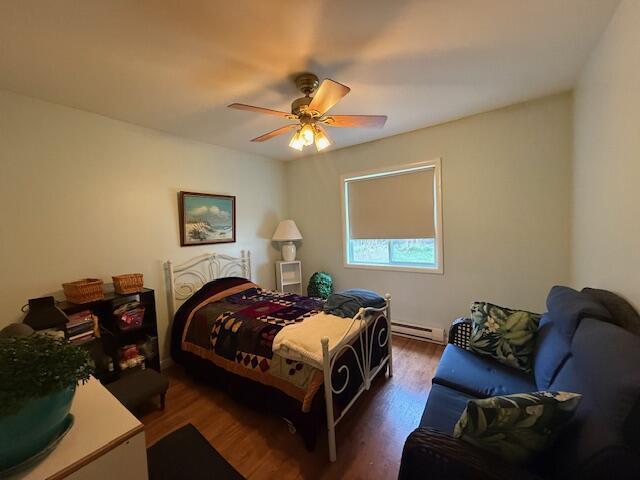 206 Great Oak Dr, Roscommon, MI 48653 - bedroom with wood finished floors, a baseboard heating unit, and ceiling fan