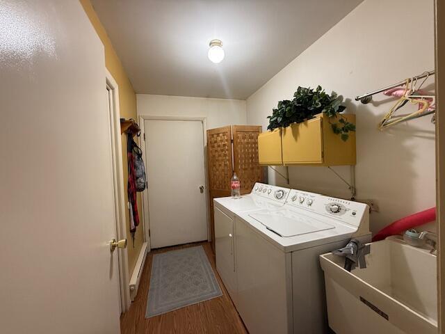 206 Great Oak Dr, Roscommon, MI 48653 - washroom featuring cabinet space, washer and clothes dryer, and wood finished floors