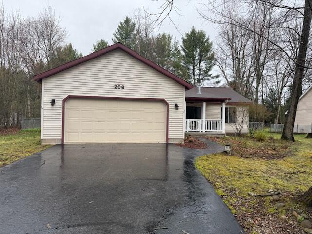 206 Great Oak Dr, Roscommon, MI 48653 - ranch-style home featuring driveway, covered porch, and a garage