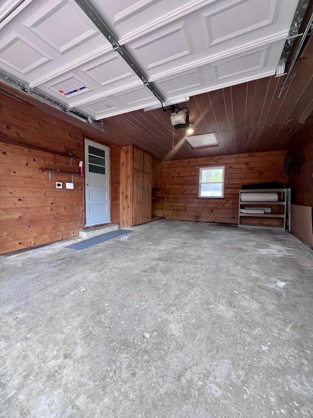 garage featuring wooden walls and a garage door opener