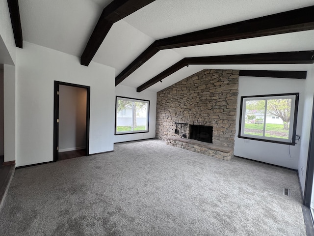 unfurnished living room featuring carpet floors, a stone fireplace, and baseboards