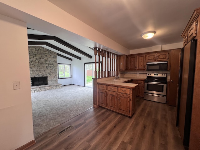 kitchen featuring stainless steel electric range oven, black microwave, a sink, open floor plan, and light countertops