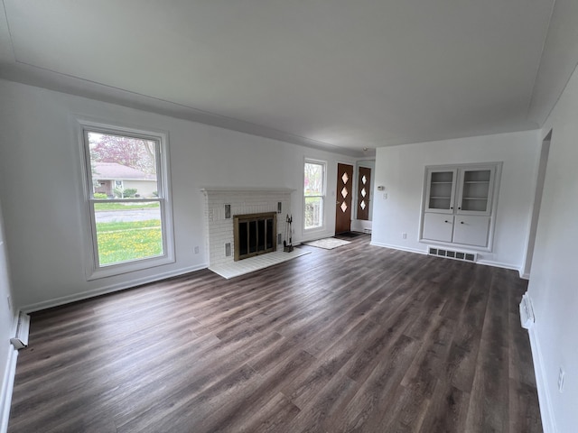 unfurnished living room featuring dark wood-type flooring, baseboards, and a fireplace