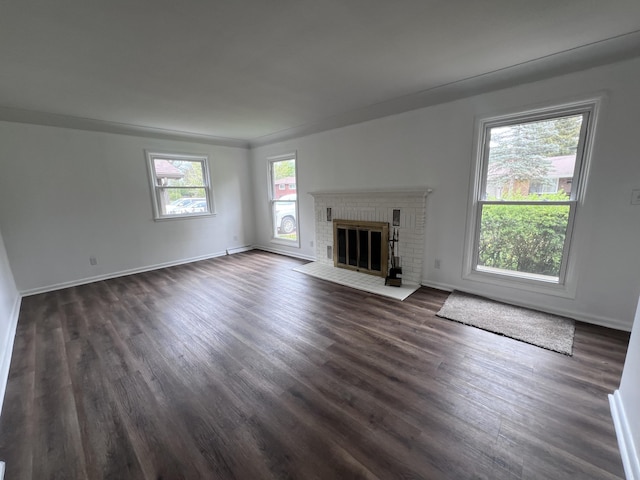 unfurnished living room with dark wood-style flooring, a fireplace, and baseboards