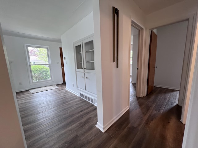 corridor with dark wood-style floors and baseboards