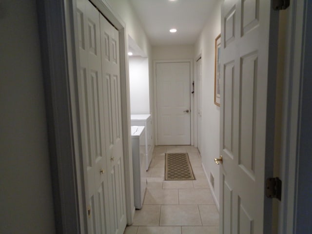 hallway with independent washer and dryer, light tile patterned floors, and recessed lighting