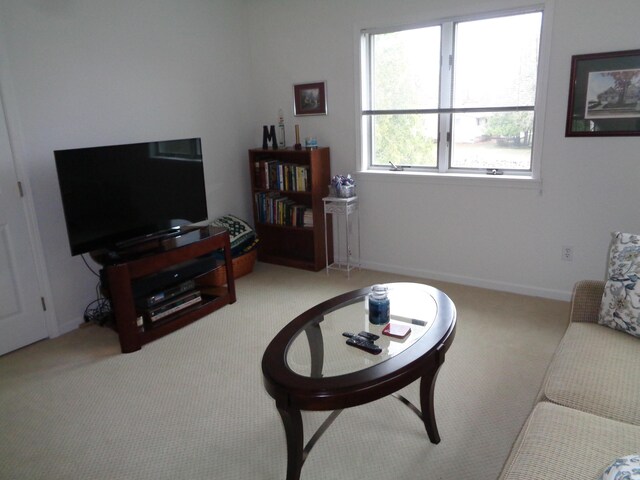carpeted living room featuring baseboards