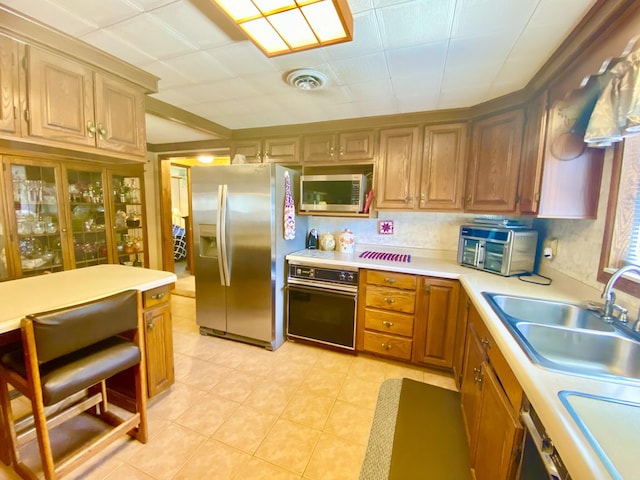 10328 Toohy Trl, Harrison, MI 48625 - kitchen with stainless steel appliances, a sink, light countertops, and light tile patterned flooring