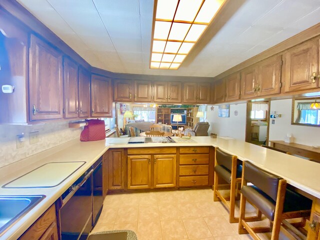 10328 Toohy Trl, Harrison, MI 48625 - kitchen with light countertops, light tile patterned flooring, a sink, a peninsula, and brown cabinets