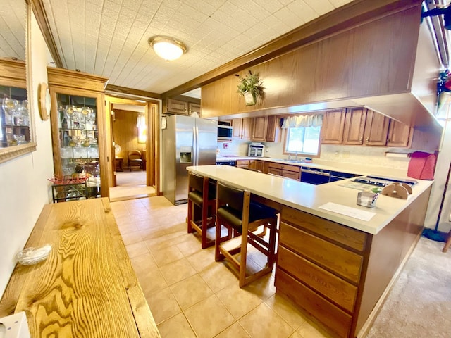10328 Toohy Trl, Harrison, MI 48625 - kitchen with light countertops, stainless steel refrigerator with ice dispenser, a sink, brown cabinets, and a peninsula