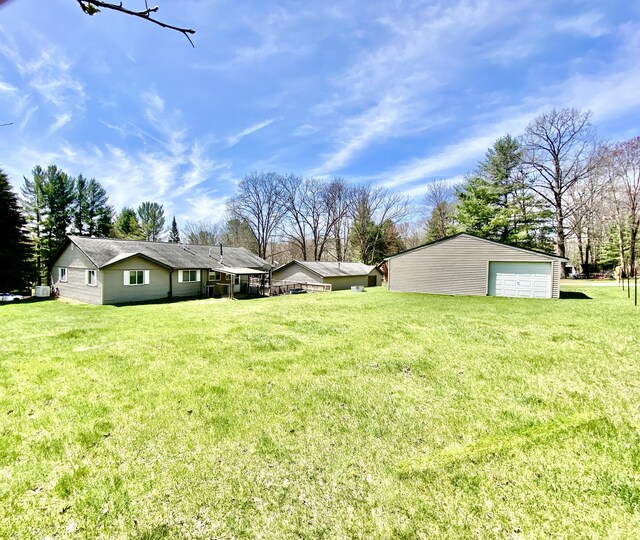 10328 Toohy Trl, Harrison, MI 48625 - view of grassy yard with a detached garage and an outbuilding