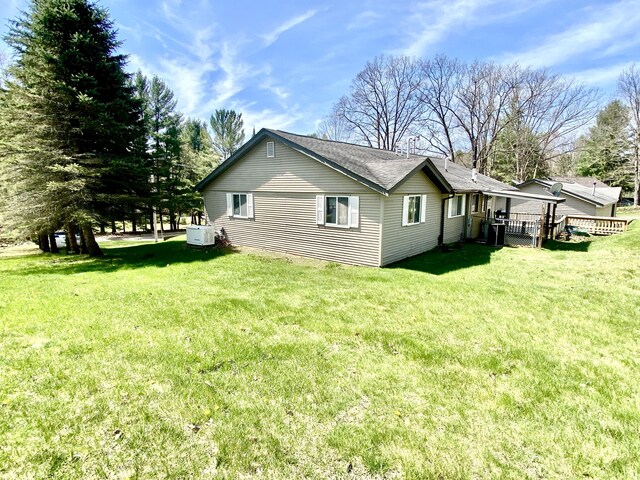 10328 Toohy Trl, Harrison, MI 48625 - view of side of home featuring a lawn, central air condition unit, and a deck