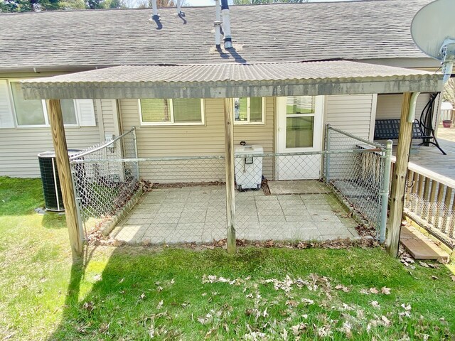 10328 Toohy Trl, Harrison, MI 48625 - back of property featuring a shingled roof, central AC, and a patio area