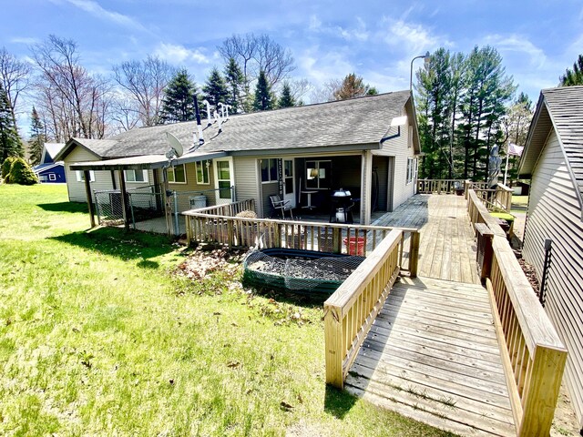 10328 Toohy Trl, Harrison, MI 48625 - rear view of property featuring a yard, a deck, and roof with shingles