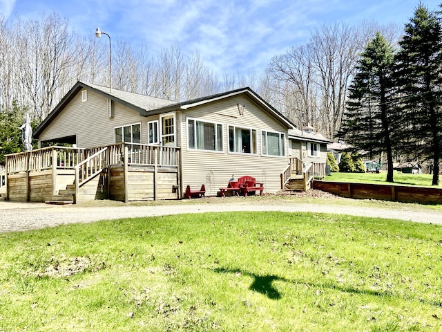 10328 Toohy Trl, Harrison, MI 48625 - view of front of house featuring a deck, a front lawn, and stairs