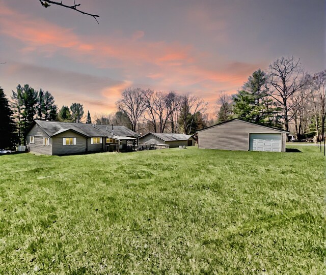10328 Toohy Trl, Harrison, MI 48625 - yard at dusk featuring a garage, a yard, and an outbuilding