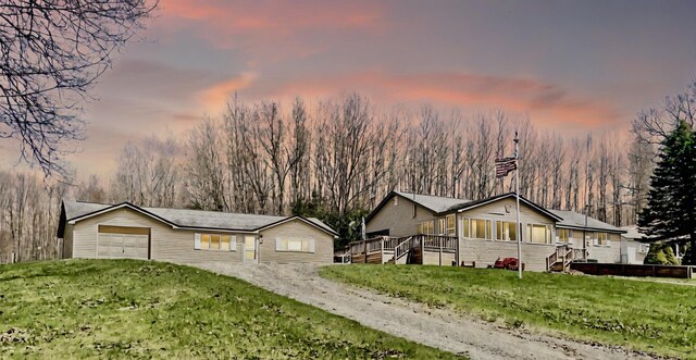 10328 Toohy Trl, Harrison, MI 48625 - view of front of property with a sunroom, a yard, an attached garage, and a deck