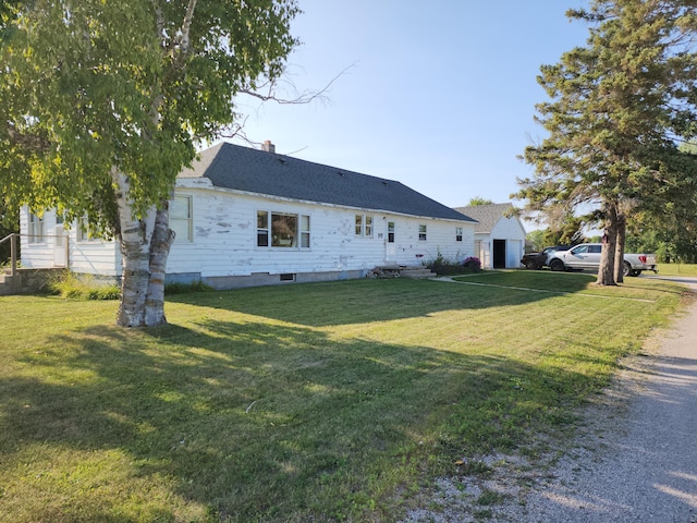 view of front facade featuring a garage, a front lawn, a chimney, and an outdoor structure