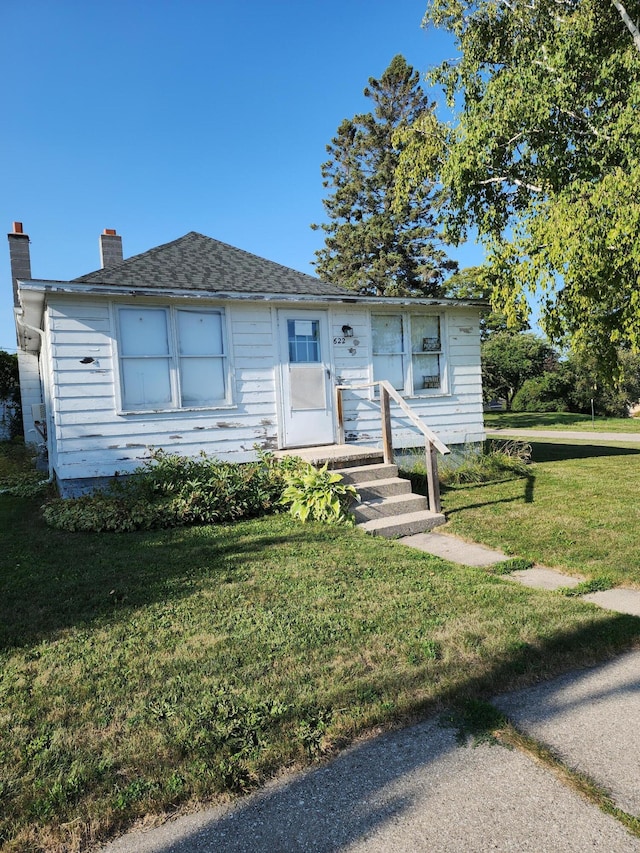 view of front of home featuring a front yard and a chimney
