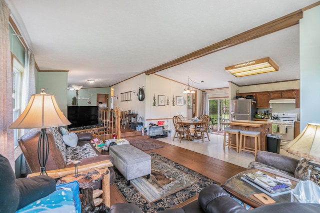 8978 Starvation Lake Rd, Mancelona, MI 49659 - living area with crown molding, light wood-style flooring, vaulted ceiling, and a chandelier