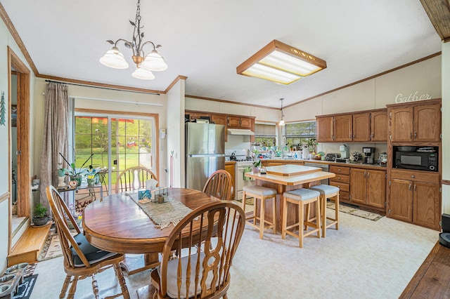 8978 Starvation Lake Rd, Mancelona, MI 49659 - dining space featuring crown molding, a chandelier, light wood-style flooring, and vaulted ceiling